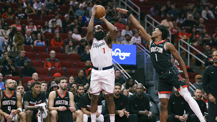 Nov 15, 2024; Houston, Texas, USA; Los Angeles Clippers guard James Harden (1) makes a three-point basket during the second quarter as Houston Rockets forward Amen Thompson (1) defends at Toyota Center. Mandatory Credit: Troy Taormina-Imagn Images