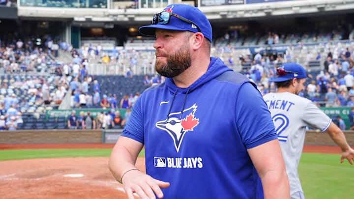 Toronto Blue Jays manager John Schneider (14) congratulates players on field after the win over the Kansas City Royals at Kauffman Stadium. 
