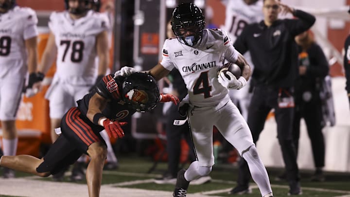 Nov 1, 2025; Salt Lake City, Utah, USA; Cincinnati Bearcats wide receiver Cyrus Allen (4) is tackled by Utah Utes cornerback Smith Snowden (2) during the second quarter at Rice-Eccles Stadium. Mandatory Credit: Rob Gray-Imagn Images