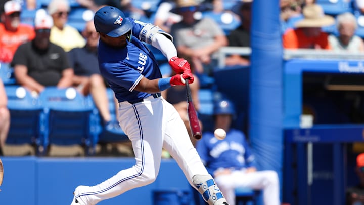 Mar 13, 2025; Dunedin, Florida, USA; Toronto Blue Jays second baseman Orelvis Martinez (13) hits a base hit against the Baltimore Orioles in the second inning during spring training at TD Ballpark.
