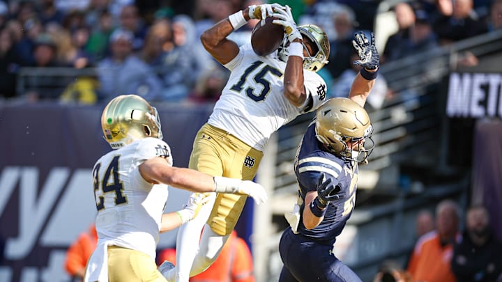 Oct 26, 2024; East Rutherford, New Jersey, USA; Notre Dame Fighting Irish cornerback Leonard Moore (15) intercepts a pass intended for Navy Midshipmen running back Eli Heidenreich (22) in front of linebacker Jack Kiser (24) during the second half at MetLife Stadium. Mandatory Credit: Vincent Carchietta-Imagn Images