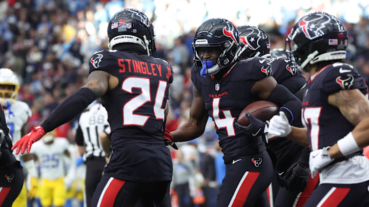 Jan 11, 2025; Houston, Texas, USA; Houston Texans corner back Kamari Lassiter (4) celebrates an intercaption during the second quarter against the Los Angeles Chargers in an AFC wild card game at NRG Stadium. Mandatory Credit: Troy Taormina-Imagn Images