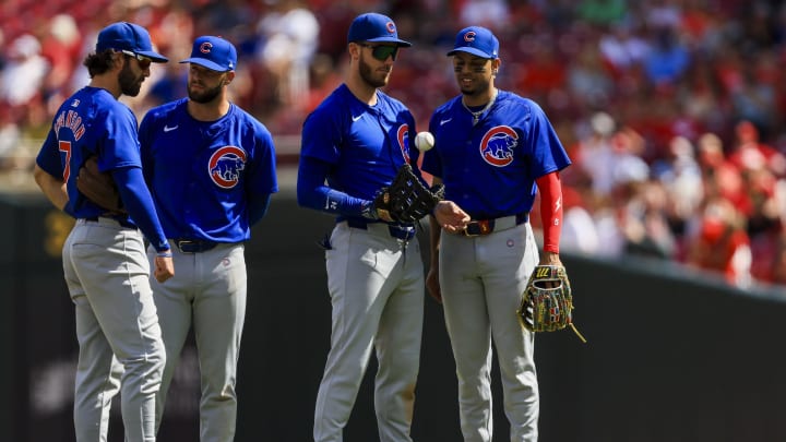 Jun 9, 2024; Cincinnati, Ohio, USA; Chicago Cubs shortstop Dansby Swanson (7), second baseman David Bote (13), first baseman Cody Bellinger (24), and third baseman Christopher Morel (5) stand on the field during a stop in play in the ninth inning against the Cincinnati Reds at Great American Ball Park