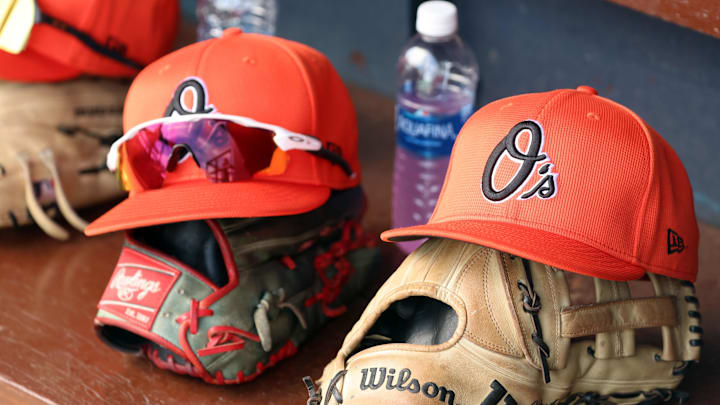 Mar 11, 2024; Tampa, Florida, USA; A detailed view of Baltimore Orioles baseball hats and gloves in the dugout during the first inning against the New York Yankees at George M. Steinbrenner Field. Mandatory Credit: Kim Klement Neitzel-Imagn Images Mar 11, 2024; Tampa, Florida, USA; A detailed view of Baltimore Orioles baseball hats and gloves in the dugout during the first inning against the New York Yankees at George M. Steinbrenner Field. Mandatory Credit: Kim Klement Neitzel-Imagn Images