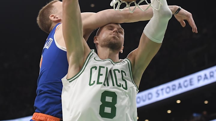 Apr 11, 2024; Boston, Massachusetts, USA;  Boston Celtics center Kristaps Porzingis (8) dunks the ball past New York Knicks guard Donte DiVincenzo (0) during the second half at TD Garden. Mandatory Credit: Bob DeChiara-Imagn Images