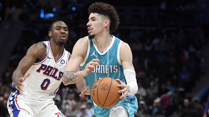 Dec 16, 2024; Charlotte, North Carolina, USA;  Charlotte Hornets guard LaMelo Ball (1) drives past Philadelphia 76ers guard Tyrese Maxey (0) during the second half at the Spectrum Center. Mandatory Credit: Sam Sharpe-Imagn Images