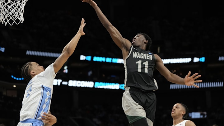 March 21, 2024, Charlotte, NC, USA; Wagner Seahawks guard Melvin Council Jr. (11) shoots against North Carolina Tar Heels guard Seth Trimble (7) in the first round of the 2024 NCAA Tournament at the Spectrum Center. Mandatory Credit: Bob Donnan-Imagn Images