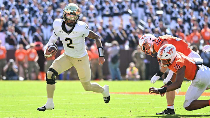 Oct 4, 2025; Blacksburg, Virginia, USA; Wake Forest Demon Deacons quarterback Robby Ashford (2) runs with the ball against Virginia Tech Hokies linebacker Noah Chambers (16) and defensive lineman Ben Bell (33) during the second quarter at Lane Stadium.