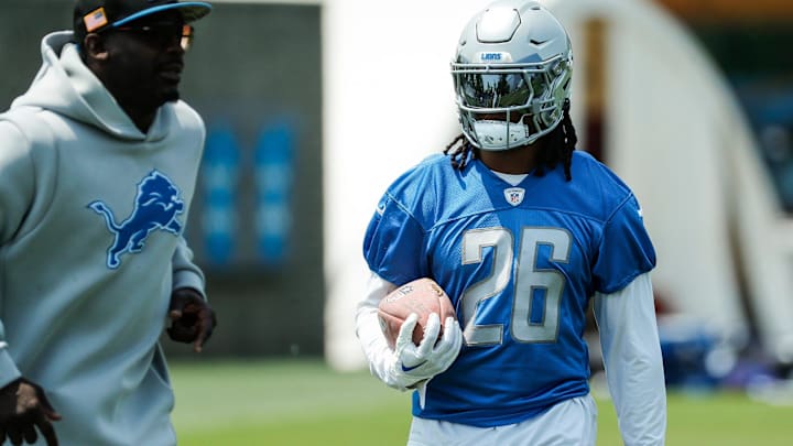 Lions running back Jahmyr Gibbs, right, practices next to running backs coach Scottie Montgomery