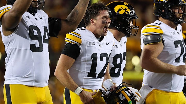 Sep 21, 2024; Minneapolis, Minnesota, USA; Iowa Hawkeyes quarterback Cade McNamara (12) celebrates quarterback Brendan Sullivans (1) touchdown against the Minnesota Golden Gophers during the second half at Huntington Bank Stadium. Mandatory Credit: Matt Krohn-Imagn Images
