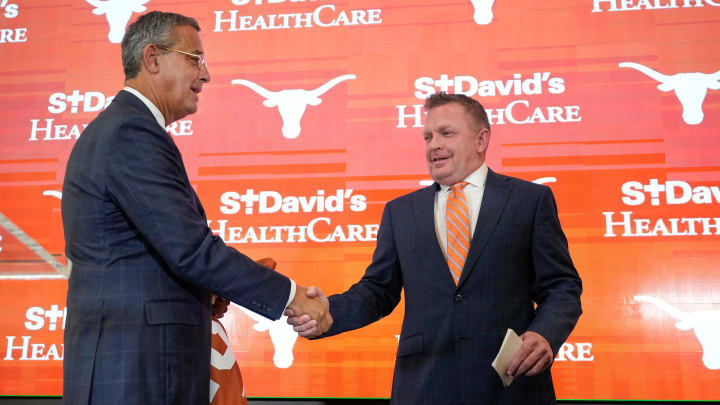 University of Texas baseball coach Jim Schlossnagle, right, is introduced by Athletic Director Chris Del Conte at his introductory news conference at the Frank Denius Family University Hall of Fame Wednesday June 26, 2024.