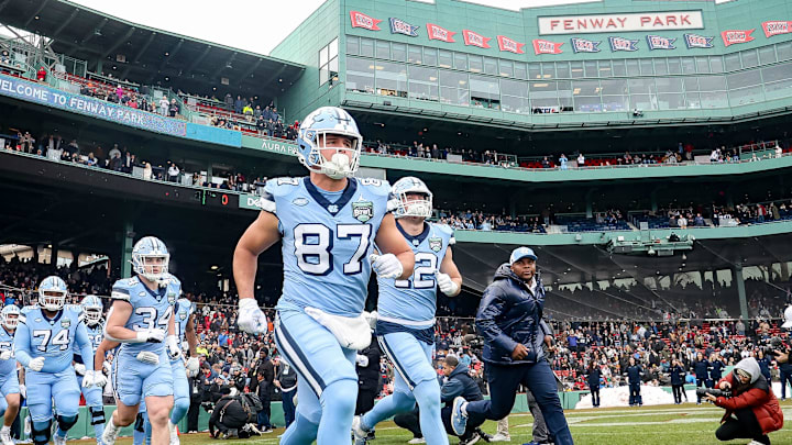 North Carolina's Cort Halsey and teammates run out of the tunnel before the third annual Wasabi Fenway Bowl against UConn at Fenway Park on Saturday, Dec. 28, 2024.