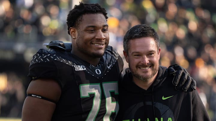 Oregon’s Isaiah World, left, takes a picture with coach Dan Lanning before the game against Southern California Nov. 22, 2025.