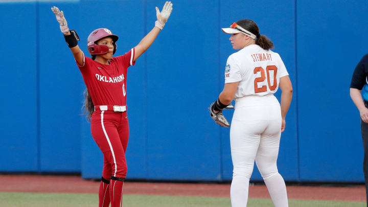 Oklahoma outfielder Rylie Boone (0) celebrates a single next to Texas' Katie Stewart (20) in the fourth inning of Game 2 of the NCAA softball Women's College World Series Championship Series game between the Oklahoma Sooners (OU) and Texas Longhorns at Devon Park in Oklahoma City, Thursday, June, 6, 2024.