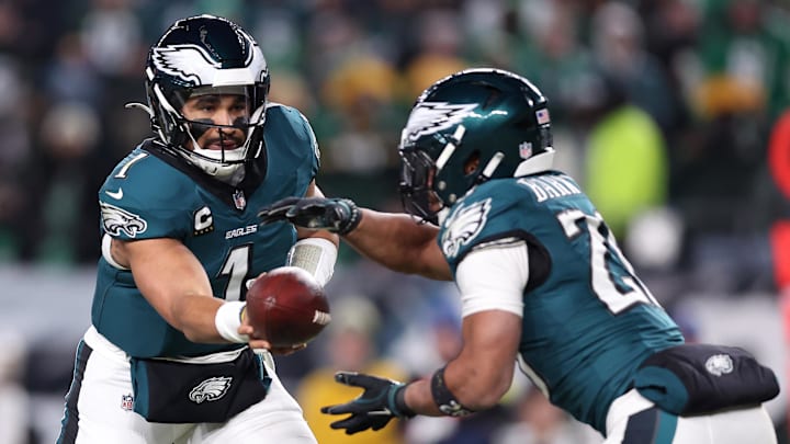 Jan 12, 2025; Philadelphia, Pennsylvania, USA; Philadelphia Eagles quarterback Jalen Hurts (1) hands the ball off to running back Saquon Barkley (26) during the third quarter in an NFC wild card game at Lincoln Financial Field. Mandatory Credit: Bill Streicher-Imagn Images