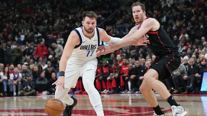 Dec 7, 2024; Toronto, Ontario, CAN; Dallas Mavericks guard Luka Doncic (77) controls the ball against Toronto Raptors center Jakob Poeltl (19) during the first quarter at Scotiabank Arena. Mandatory Credit: Nick Turchiaro-Imagn Images