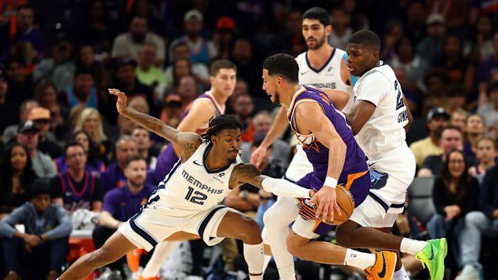 Oct 29, 2025; Phoenix, Arizona, USA; Memphis Grizzlies guard Ja Morant (12) defends against Phoenix Suns guard Devin Booker (1) during the second half at the Mortgage Matchup Center. Mandatory Credit: Mark J. Rebilas-Imagn Images Oct 29, 2025; Phoenix, Arizona, USA; Memphis Grizzlies guard Ja Morant (12) defends against Phoenix Suns guard Devin Booker (1) during the second half at the Mortgage Matchup Center. Mandatory Credit: Mark J. Rebilas-Imagn Images