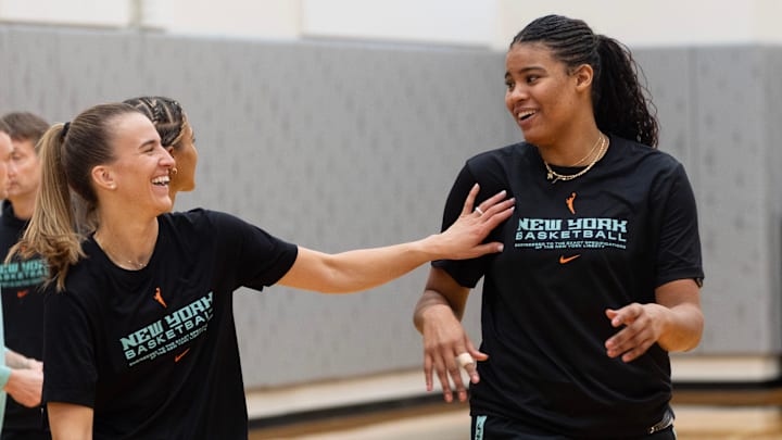 Former Oregon Duck Sabrina Ionescu, left, jokes with her New York Liberty teammate Nyara Sabally during a practice session at Matthew Knight Arena Sunday.