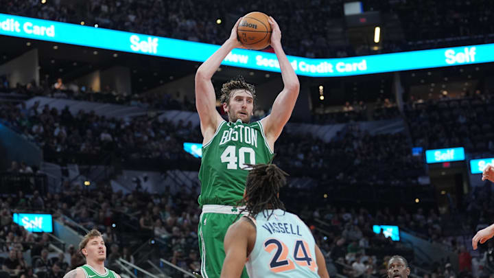 Mar 29, 2025; San Antonio, Texas, USA;  Boston Celtics center Luke Kornet (40) rebounds a ball in front of San Antonio Spurs guard Devin Vassell (24) in the second half at Frost Bank Center. Mandatory Credit: Daniel Dunn-Imagn Images