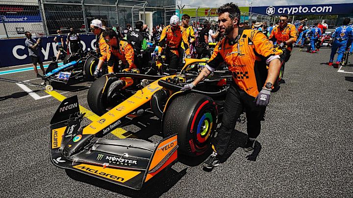 May 4, 2024; Miami Gardens, Florida, USA; Crewmembers push the car of McLaren driver Lando Norris (4) on the grid before the F1 Sprint Race at Miami International Autodrome. Mandatory Credit: John David Mercer-Imagn Images