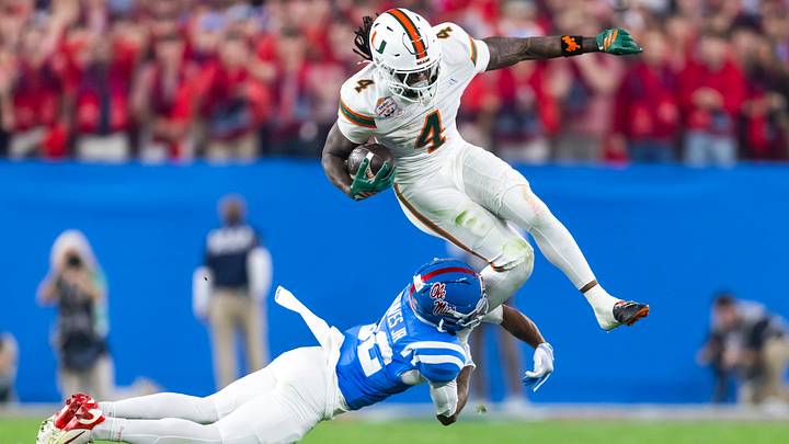 Jan 8, 2026; Glendale, AZ, USA; Miami Hurricanes running back Mark Fletcher Jr. (4) leaps as he is tackled by diving Mississippi Rebels cornerback Chris Graves Jr. (32) during the 2026 Fiesta Bowl and semifinal game of the College Football Playoff at State Farm Stadium. Mandatory Credit: Mark J. Rebilas-Imagn Images