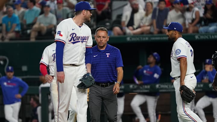 May 12, 2025; Arlington, Texas, USA; Texas Rangers pitcher Luke Jackson (77) is checked on by a trainer after being hit with a batted ball during the ninth inning against the Colorado Rockies at Globe Life Field. Jackson would leave the game after being hit. May 12, 2025; Arlington, Texas, USA; Texas Rangers pitcher Luke Jackson (77) is checked on by a trainer after being hit with a batted ball during the ninth inning against the Colorado Rockies at Globe Life Field. Jackson would leave the game after being hit.
