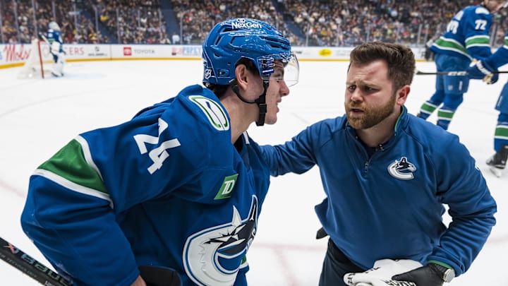 Jan 25, 2026; Vancouver, British Columbia, CAN; A member of the Vancouver Canucks training staff tends to injured defenseman Zeev Buium (24) against the Pittsburgh Penguins in the first period at Rogers Arena. Mandatory Credit: Bob Frid-Imagn Images
