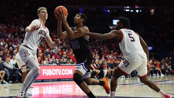 Nov 19, 2023; Tucson, Arizona, USA; Texas-Arlington Mavericks guard Aaron Cash (00) shoots a basket against Arizona Wildcats center Motiejus Krivas (14) and guard KJ Lewis (5) during the first half at McKale Center.