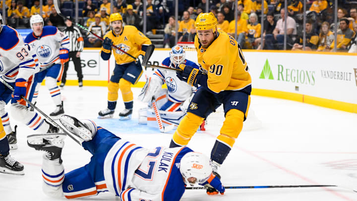 Oct 31, 2024; Nashville, Tennessee, USA; Nashville Predators center Ryan O'Reilly (90) checks Edmonton Oilers defenseman Brett Kulak (27)  during the first period at Bridgestone Arena. Mandatory Credit: Steve Roberts-Imagn Images