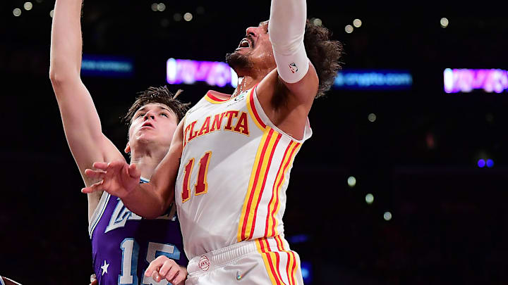 Jan 7, 2022; Los Angeles, California, USA; Atlanta Hawks guard Trae Young (11) moves to the basket against Los Angeles Lakers guard Austin Reaves (15) during the first half at Crypto.com Arena. Mandatory Credit: Gary A. Vasquez-Imagn Images