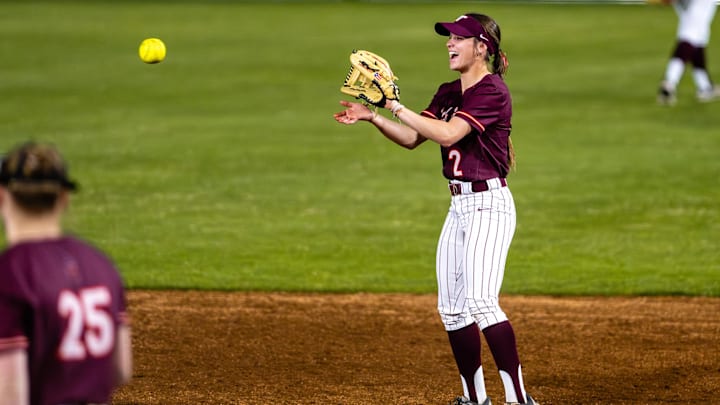 Gaby Mizelle (2) catches the softball as it passes around the diamond.