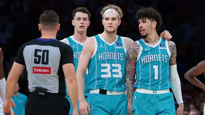Oct 28, 2025; Miami, Florida, USA; Charlotte Hornets guard LaMelo Ball (1) walks with forward Liam McNeeley (33) after receiving a technical foul for an obscene gesture during the fourth quarter against the Miami Heat at Kaseya Center. Mandatory Credit: Sam Navarro-Imagn Images