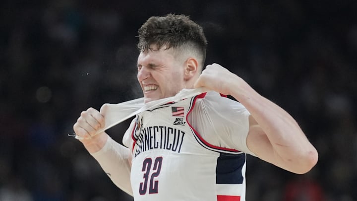 Apr 8, 2024; Glendale, AZ, USA; Connecticut Huskies center Donovan Clingan (32) reacts and rips his undershirt in the second half against the Purdue Boilermakers in the national championship game of the Final Four of the 2024 NCAA Tournament at State Farm Stadium. Mandatory Credit: Robert Deutsch-USA TODAY Sports