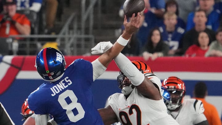 Oct 13, 2024; East Rutherford, New Jersey, USA;  Cincinnati Bengals defensive tackle B.J. Hill (92) forces an interception on a throw by New York Giants quarterback Daniel Jones (8) during the first quarter at MetLife Stadium. Mandatory Credit: Robert Deutsch-Imagn Images