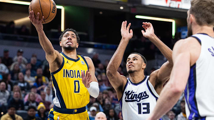 Mar 31, 2025; Indianapolis, Indiana, USA; Indiana Pacers guard Tyrese Haliburton (0) shoots the ball while Sacramento Kings forward Keegan Murray (13)  defends in the first half at Gainbridge Fieldhouse.
