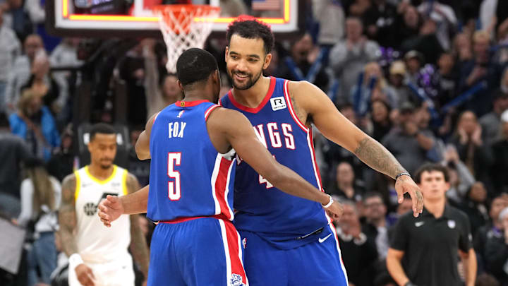 Nov 16, 2024; Sacramento, California, USA; Sacramento Kings guard De'Aaron Fox (5) celebrates with forward Trey Lyles (center right) after defeating the Utah Jazz at Golden 1 Center. Mandatory Credit: Darren Yamashita-Imagn Images