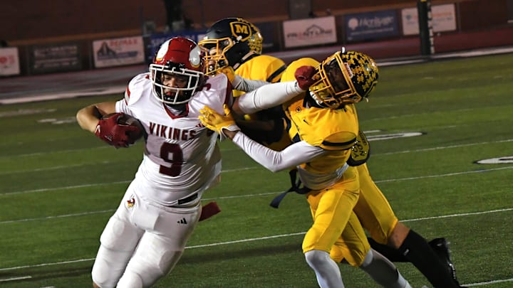 Landen Miree (9) stiff-arms his way to a Princeton first down in the OHSAA Division I football regional semifinals Nov. 15, 2024, at Dwire Field Mason, Ohio.