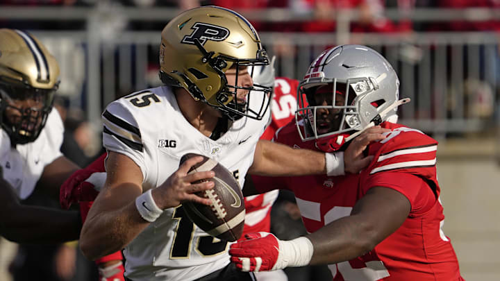 Purdue Boilermakers quarterback Ryan Browne (15) is pursued by Ohio State Buckeyes defensive end Joshua Mickens (52) 