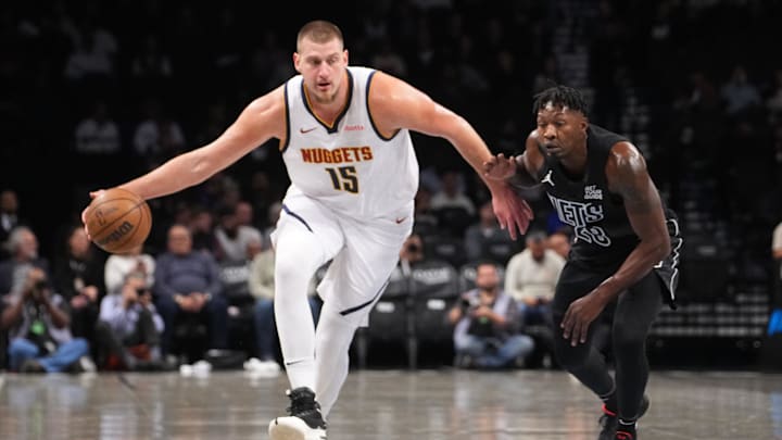 Oct 29, 2024; Brooklyn, New York, USA; Denver Nuggets center Nikola Jokic (15) dribbles the ball against Brooklyn Nets power forward Dorian Finney-Smith (28) during the first half at Barclays Center. Mandatory Credit: Gregory Fisher-Imagn Images