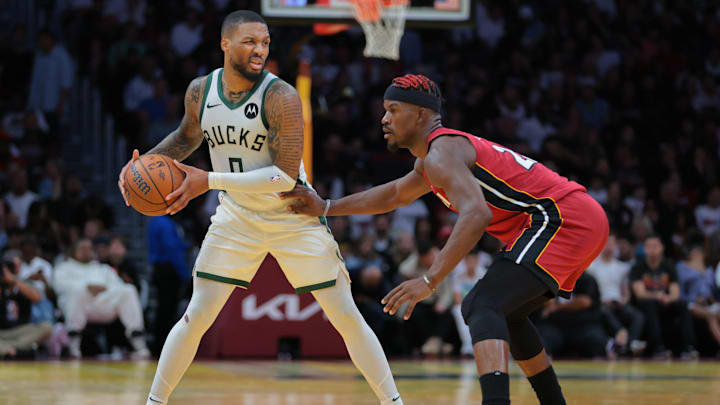 Nov 26, 2024; Miami, Florida, USA; Milwaukee Bucks guard Damian Lillard (0) protects the basketball from Miami Heat forward Jimmy Butler (22) during the third quarter at Kaseya Center. Mandatory Credit: Sam Navarro-Imagn Images