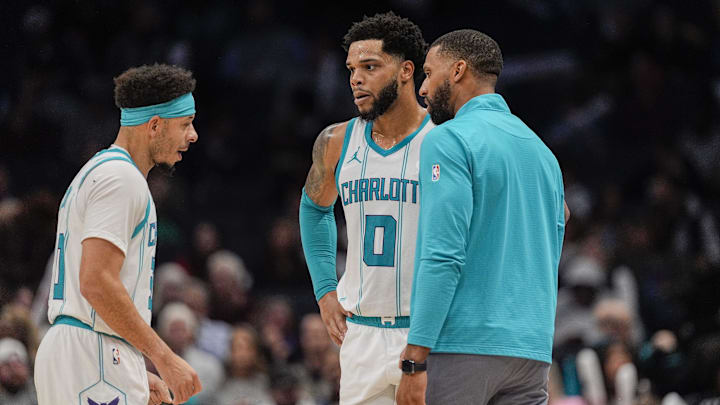 Feb 5, 2025; Charlotte, North Carolina, USA; Charlotte Hornets forward Miles Bridges (0), guard Seth Curry (30) talk with head coach Charles Lee during a free throw by Milwaukee Bucks during the second half at Spectrum Center. Mandatory Credit: Jim Dedmon-Imagn Images