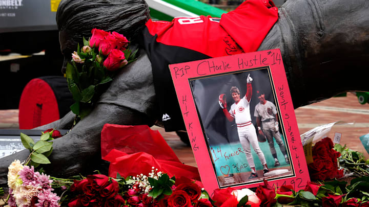 As word spread of the death of former Cincinnati Reds player/manager, Pete Rose at 83, many came downtown to pay their respects at the statue of Rose sliding into home at the entrance of Great American Ballpark, Tuesday, Oct. 1, 2024. The statue was installed in 2017. Rose died at his home in Nevada, Sept. 30, 2024.