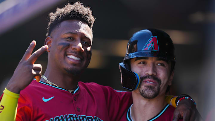 Sep 18, 2024; Denver, Colorado, USA; Arizona Diamondbacks outfielder Corbin Carroll (7) (right) celebrates his solo home run with shortstop Geraldo Perdomo (2) (left) in the first inning against the Colorado Rockies at Coors Field. Mandatory Credit: Ron Chenoy-Imagn Images