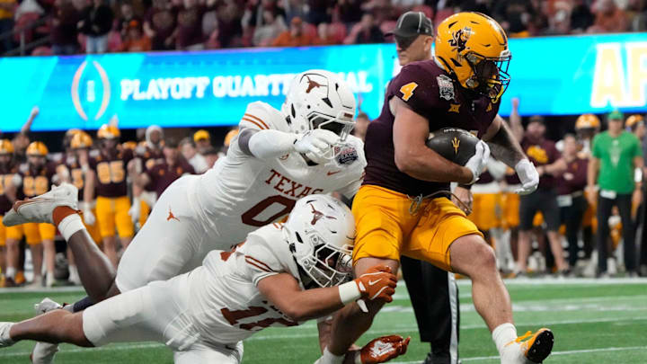 Arizona State running back Cam Skattebo (4) runs past Texas linebacker Anthony Hill Jr. (0) and Texas linebacker Liona Lefau (18) during the third quarter of the Chick-fil-A Peach Bowl in Atlanta on Wednesday, Jan. 1, 2025.