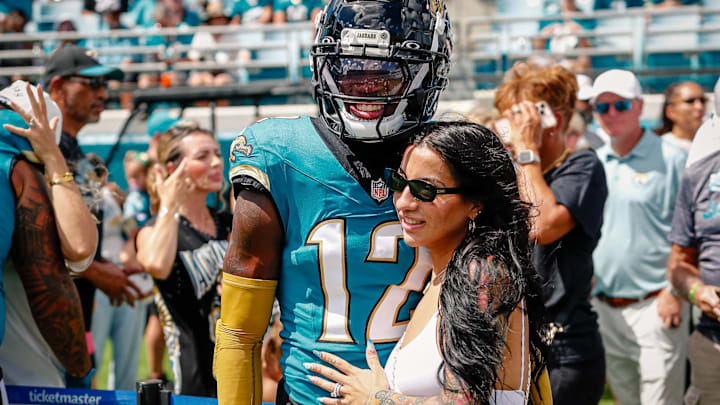 Jacksonville Jaguars player Travis Hunter (12) with his wife during pregame against the Houston Texans at EverBank Stadium.