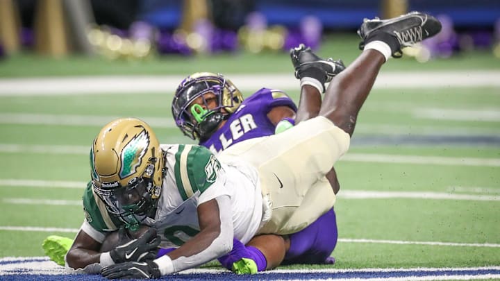 DeSoto's Myson Cook Johnson is tripped up by Miller's Delson Cavaness during Friday's game at the Alamodome on Sept. 13, 2024, in San Antonio, Texas.