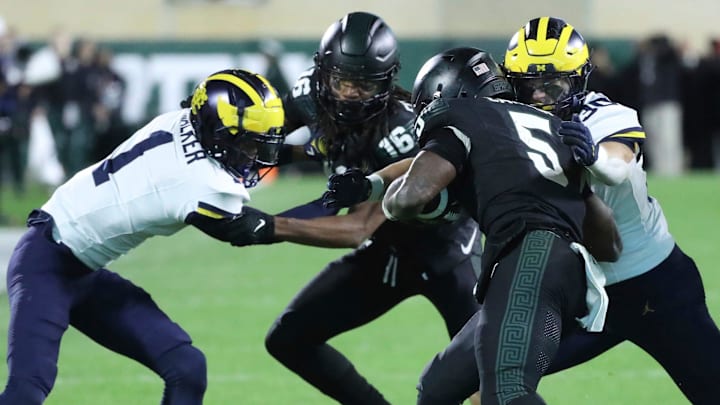 Michigan Wolverines linebacker Jimmy Rolder (30) tackles Michigan State Spartans running back Nathan Carter (5) during second-half action at Spartan Stadium in East Lansing on Saturday, Oct. 21, 2023.