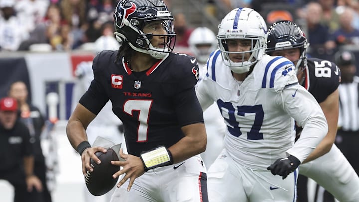 Oct 27, 2024; Houston, Texas, USA; Houston Texans quarterback C.J. Stroud (7) looks for an open receiver as Indianapolis Colts defensive end Laiatu Latu (97) applies defensive pressure during the game at NRG Stadium. Mandatory Credit: Troy Taormina-Imagn Images