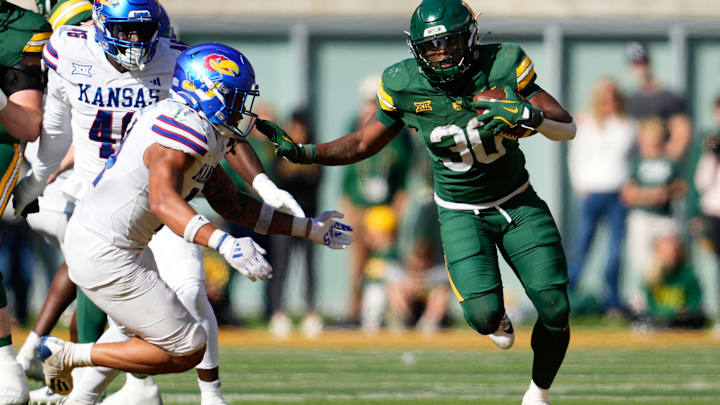 Nov 30, 2024; Waco, Texas, USA;  Baylor Bears running back Bryson Washington (30) runs the ball as Kansas Jayhawks safety Jalen Dye (14) defends during the second half at McLane Stadium. Mandatory Credit: Chris Jones-Imagn Images