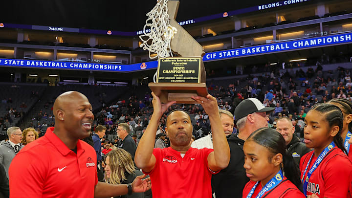 Etiwanda coach Stan Delus holds up the trophy following his team's victory in the California (CIF) State Open Division championship game.